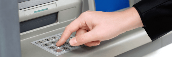 Person using ATM pin pad