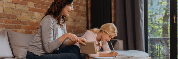 Mom and daughter writing in notepad