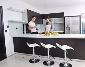 happy young couple have fun in  modern kitchen indoor  while preparing fresh fruits and vegetables food salad