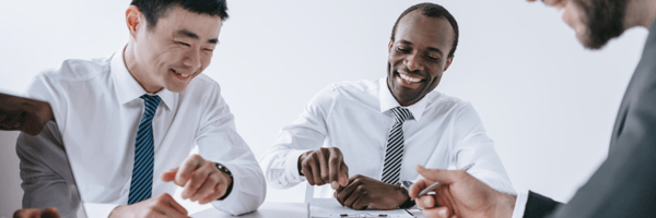 Men smiling while on their laptops