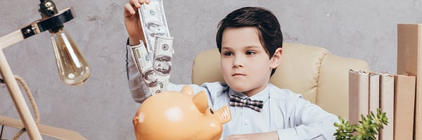 Boy looking at money in piggy bank.