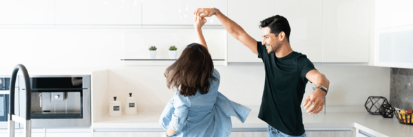 Couple dancing in their kitchen at home. 