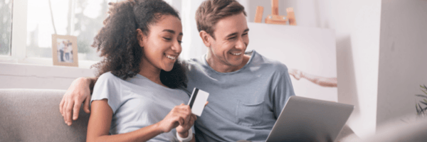 Couple using a credit card to shop online. 
