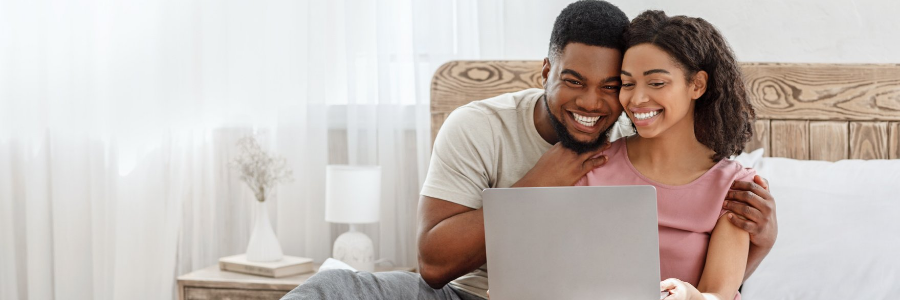 Couple smiling at laptop 