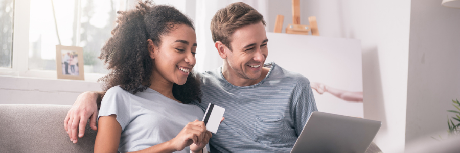 Couple holding a tablet and a credit card
