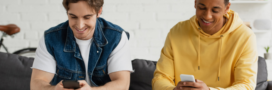 Two guys on their phones sitting on the couch