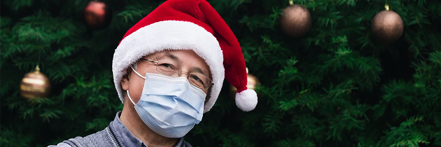 Man wearing a Santa hat and a surgical mask. 